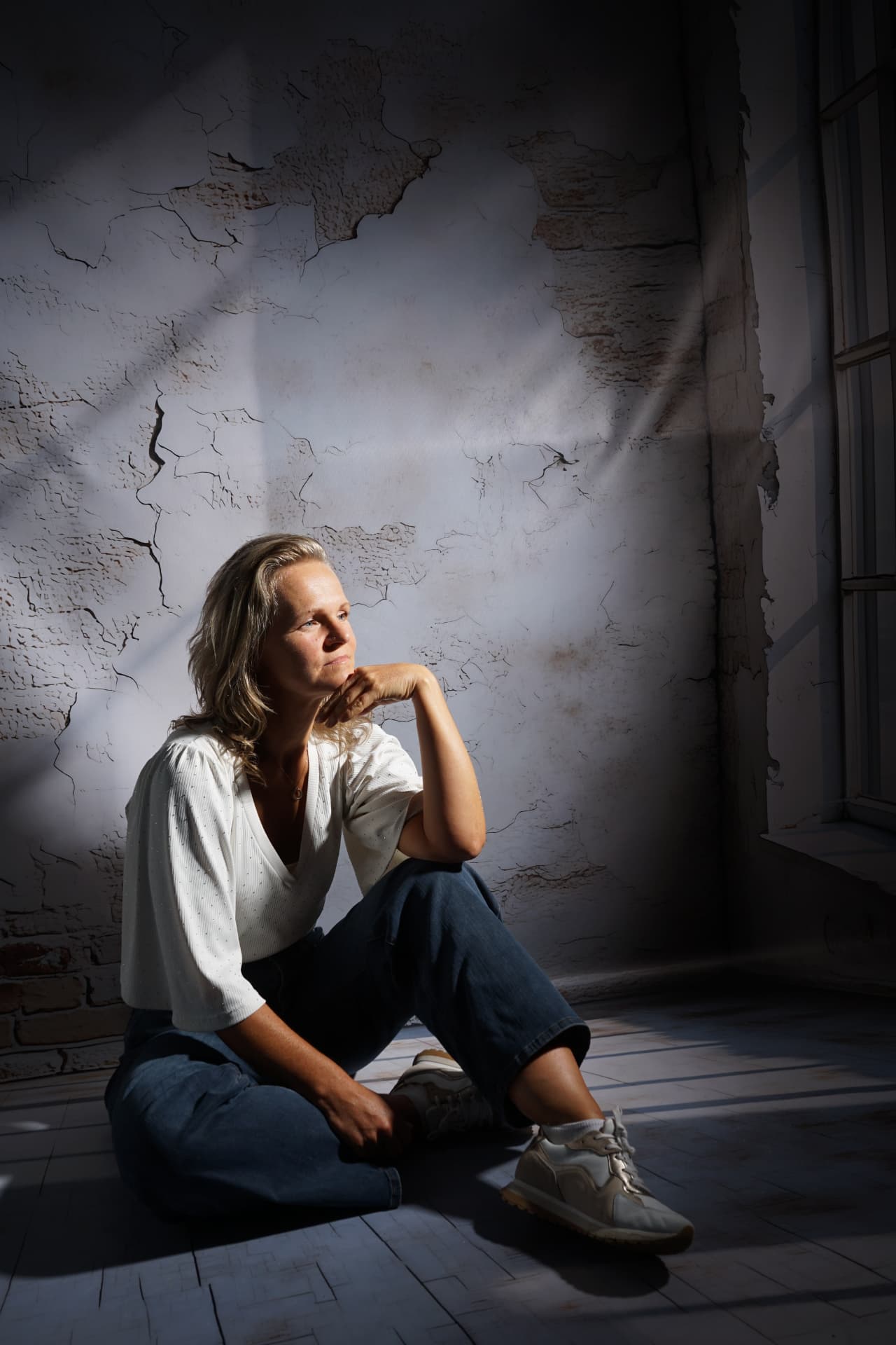 Portret van de vrouw achter Ik hou van mij, zittend tegen een verweerde muur